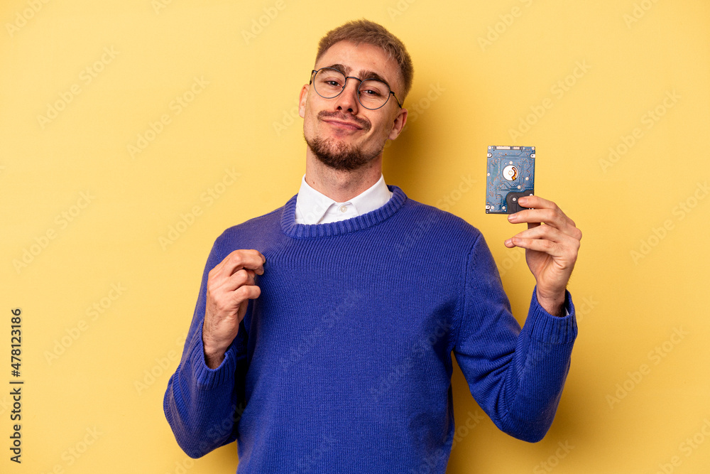 Young computer man isolated on yellow background