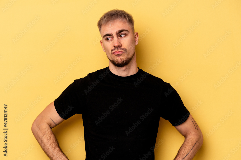 Young caucasian man isolated on yellow background confused, feels doubtful and unsure. Young caucasian man isolated on yellow background confused, feels doubtful and unsure.