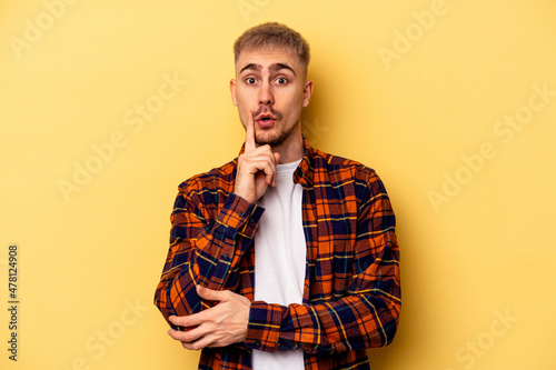 Young caucasian man isolated on yellow background having some great idea, concept of creativity. © Asier