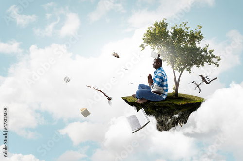 Young black man sitting and meditating © Sergey Nivens