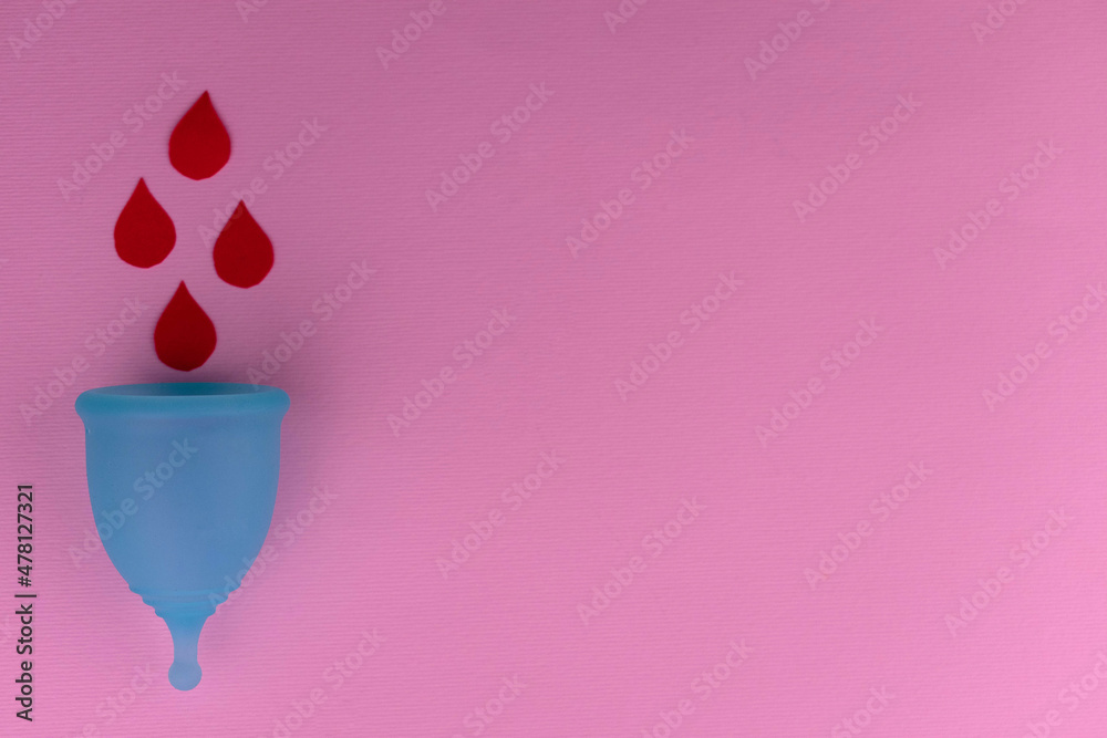 Menstrual cup with blood drops on a pink background. Copy space. Menstrual cup with blood drops on a pink background. Copy space.