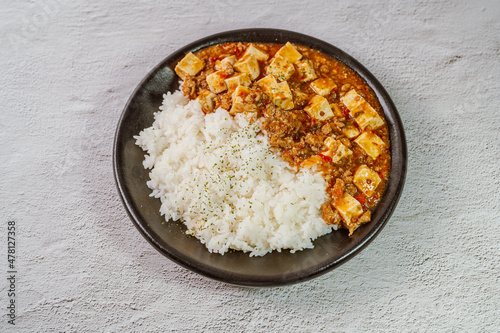 Chinese food mapo tofu dish and rice on black plate
