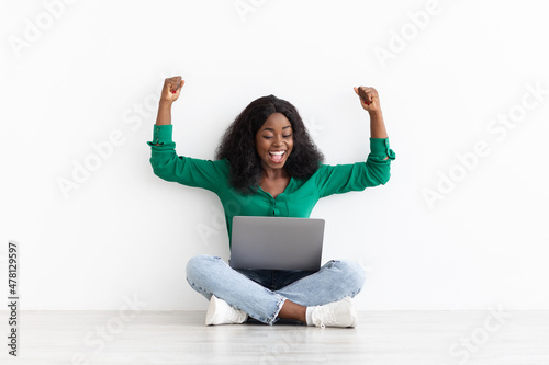 Joyful african american woman looking for job online, using laptop © Prostock-studio