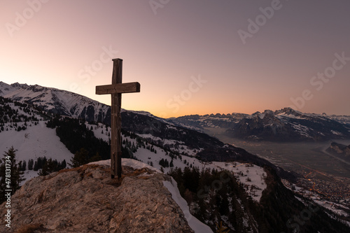 Landquart, Switzerland, December 19, 2021 Holy cross on the peak of the mount Pizalun in the evening