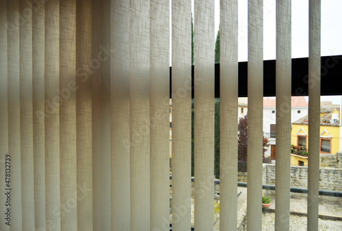 Cortinas de lamas verticales de tela para graduar la luz ambiental de las ventanas de una casa. Decoración de interiores photo