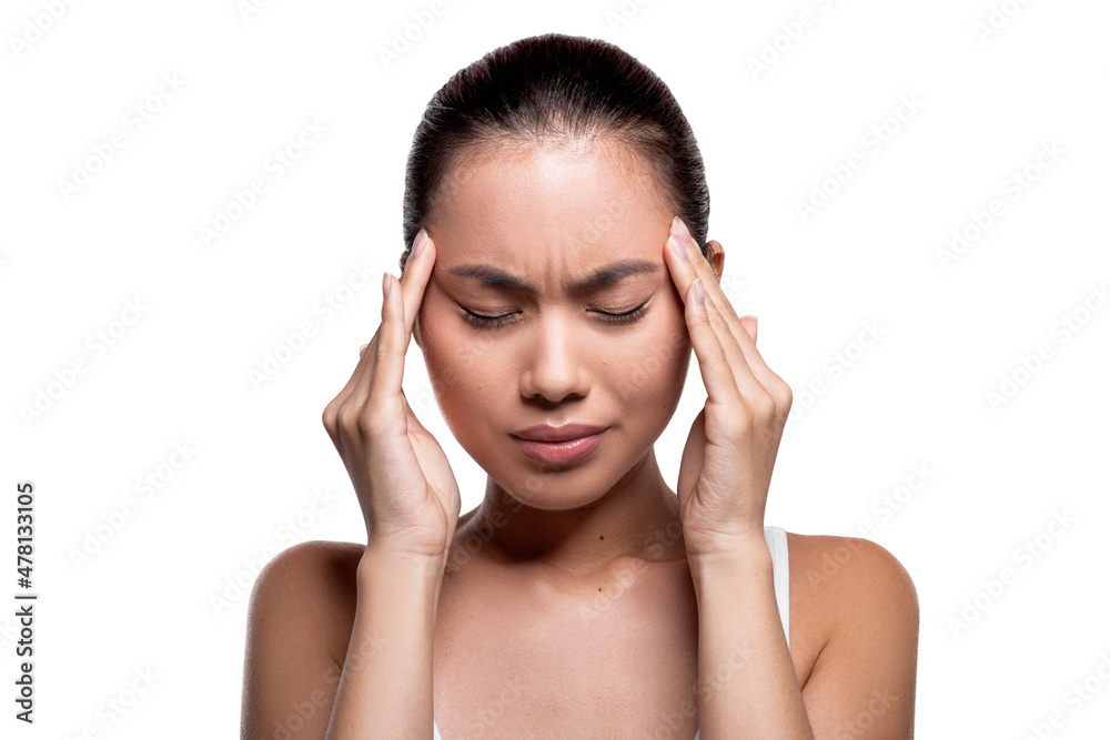 Upset millennial korean lady massaging her temples Upset millennial korean lady massaging her temples