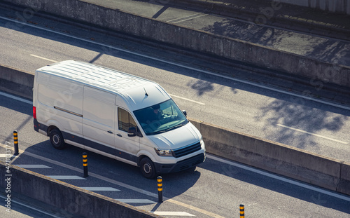 White cargo minivan on the road, delivery van service photo