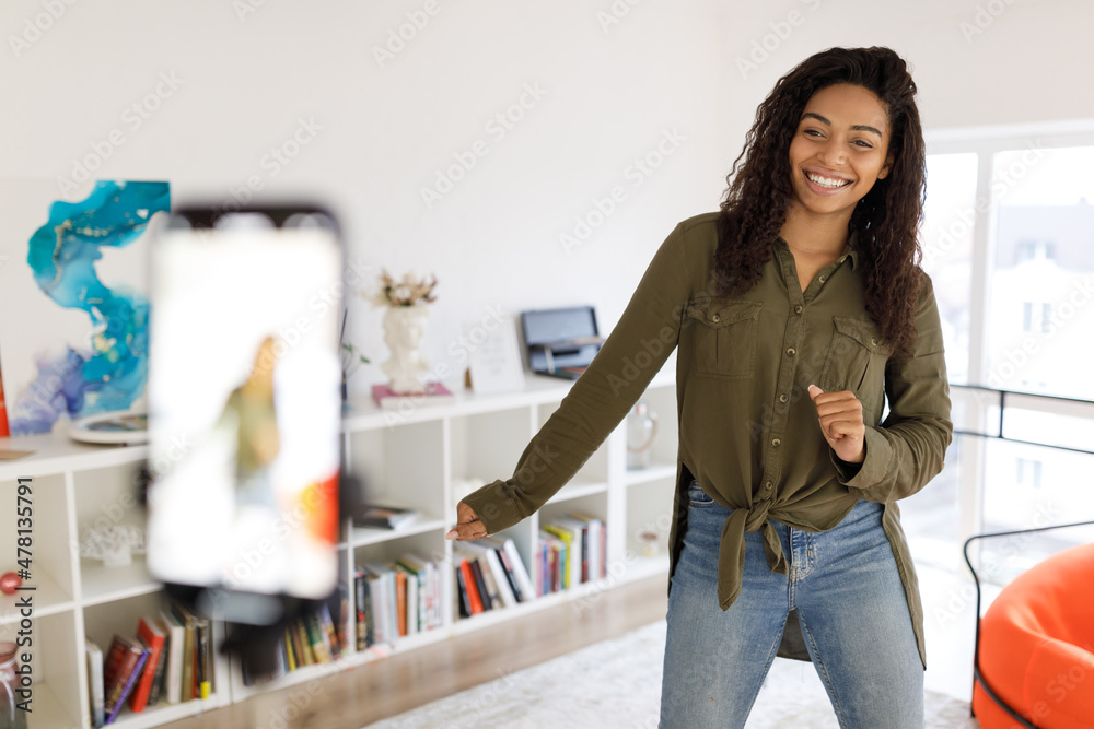 Cheerful black woman filming dance video on cellphone Cheerful black woman filming dance video on cellphone