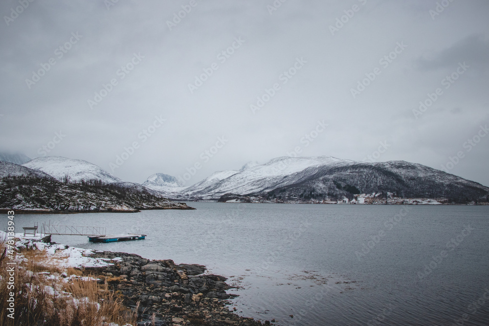 Panorama of the Norwegian Sea and the Andesfjord with fog and snow-covered hills. Hills on Senja Island, Norway. Exploring northern Norway