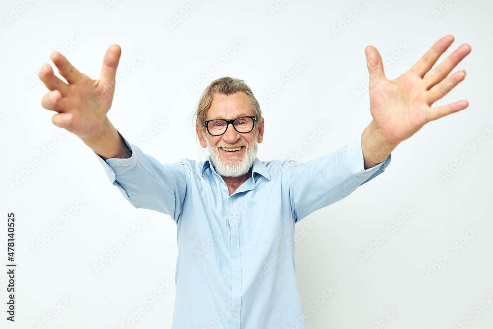 Photo of retired old man in blue shirts gestures with his hands isolated background Photo of retired old man in blue shirts gestures with his hands isolated background