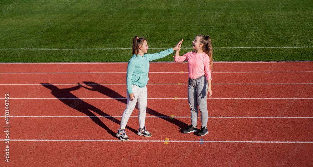 Obraz premium Having a little break. having fun. teen girls warming up on stadium. kids in sportswear take five. children relax after exercise on racing track. healthy childhood. workout on fresh air outdoor