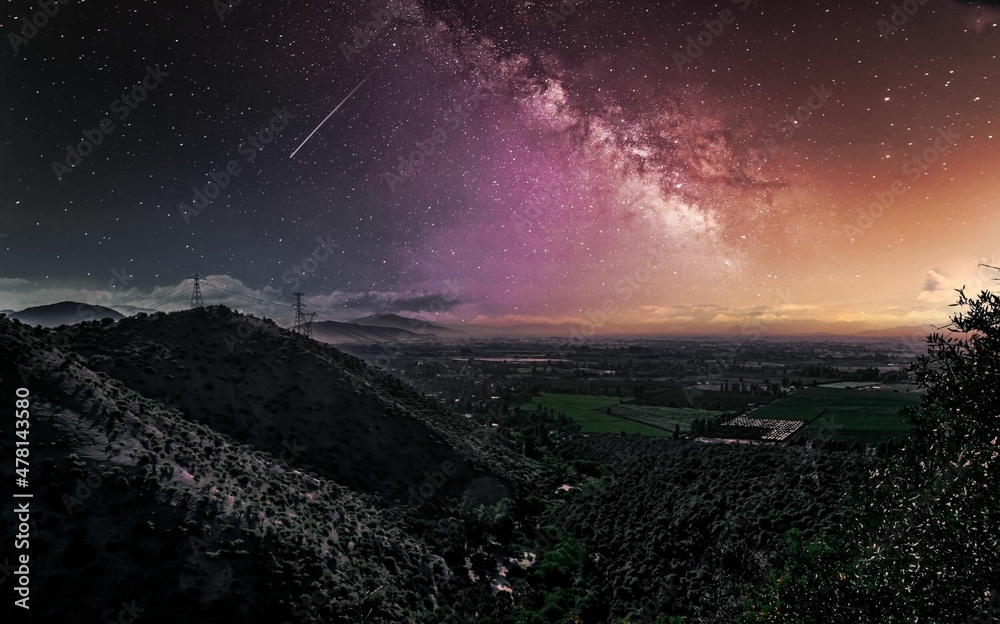 Paisaje nocturno del campo con una montaña, cerro, cielo con estrellas