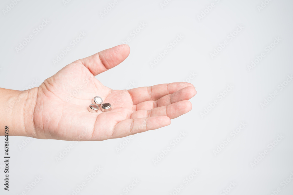 Hand holding round lithium button cell battery Hand holding round lithium button cell battery