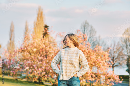 Outdoor portrait of young happy blond woman in spring park, emotional female model having fun on sunny warm day © annanahabed
