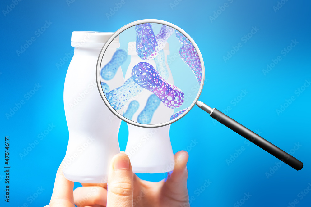 Probiotic yogurt. Magnifying glass with probiotic molecules. Jars with probiotic yogurt on blue. Concept of fermented milk products with beneficial microorganisms. Microbiome research. - obrazy, fototapety, plakaty 