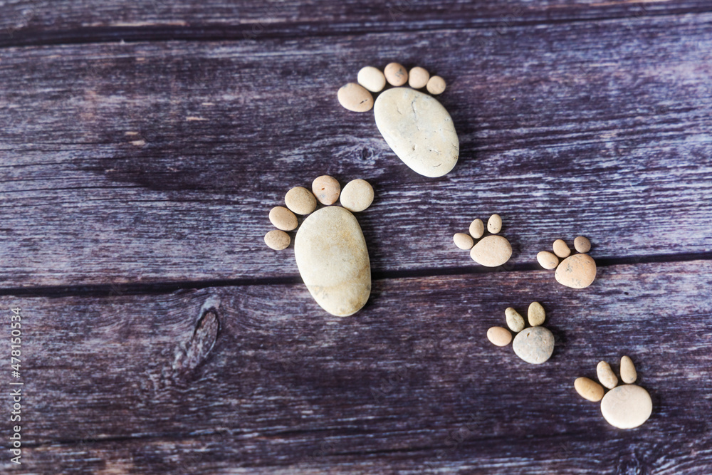 Funny human footprints from stones on a wooden background. Funny human footprints from stones on a wooden background.