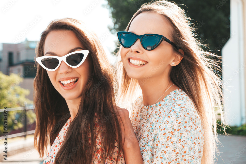 Young beautiful smiling hipster woman in trendy summer clothes. Sexy carefree woman posing on the street background at sunset. Positive model outdoors. Cheerful and happy in sunglasses