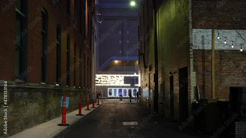 A static evening view of a dark alley in a large city. A static evening view of a dark alley in a large city.