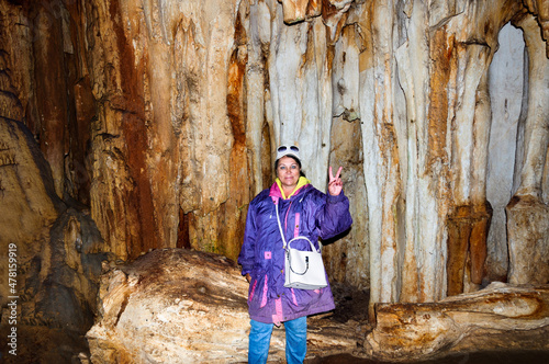 Fototapeta Naklejka Na Ścianę i Meble -  A woman, a member of a tourist group, poses against the backdrop of a cave. Emine-Bair Khosar cave