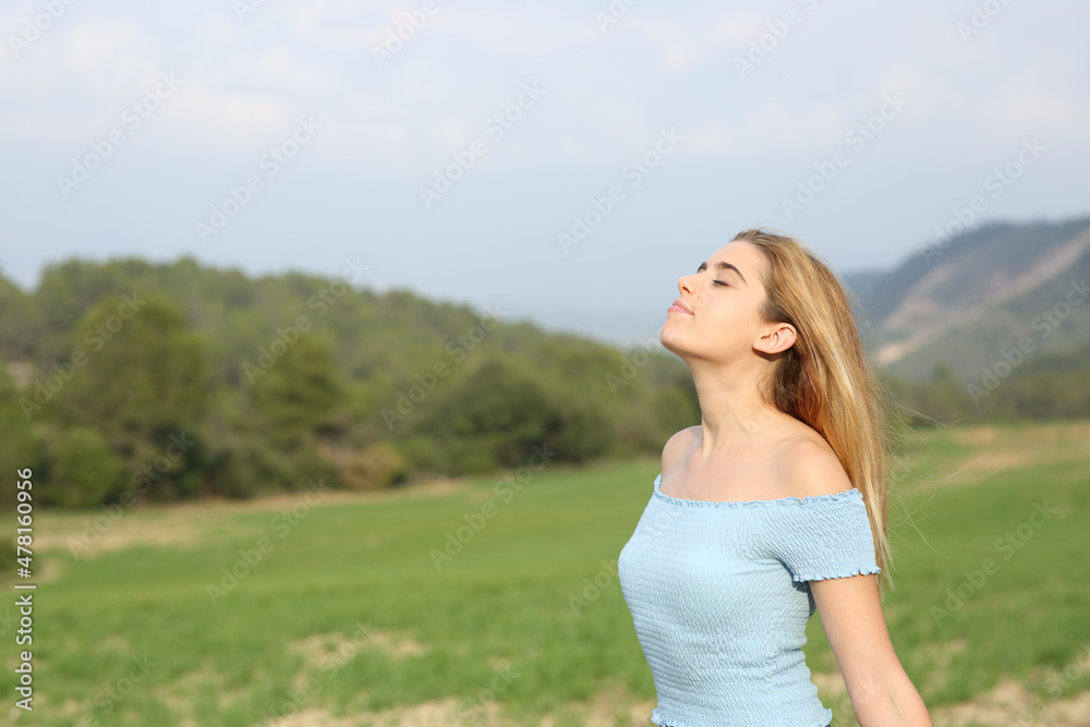 Relaxed teen breathing fresh air in a field Relaxed teen breathing fresh air in a field