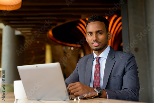 Photography Portrait of African businessman wearing suit and tie in coffee shop