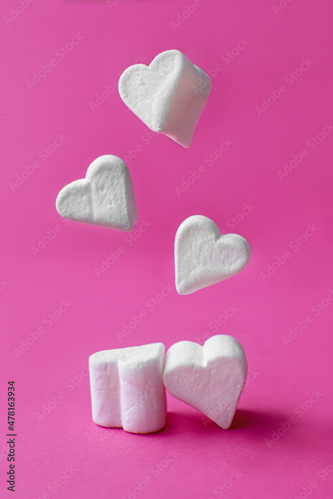 Fototapeta premium Minimalist Valentine's day. White marshmallow hearts on pink pastel background. Composition for Valentins Day, Mother's Day, March 8 or Women's Day.