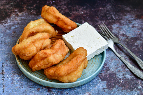 Traditional Bulgarian home made deep fried  patties  covered with sugar  оn rustic backgroud.Mekitsa or Mekica,  on wooden  rustic  background. Made of kneaded dough that is deep fried  photo