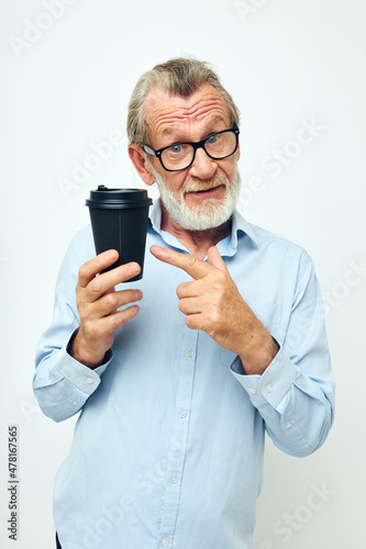 Senior grey-haired man with glasses and shirts disposable glass isolated background © Tatiana