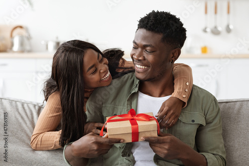 Emotional african american woman hugging her lover, giving present