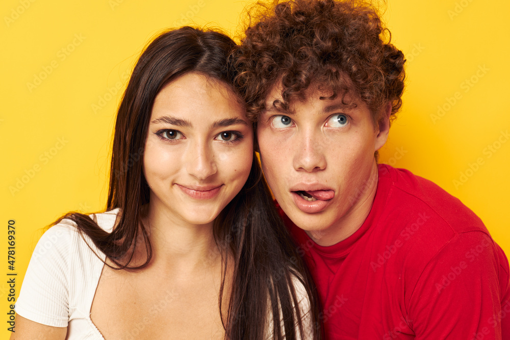portrait of a man and a woman Friendship posing hugs together yellow background unaltered portrait of a man and a woman Friendship posing hugs together yellow background unaltered