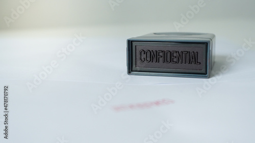 Close up rubber stamping that says confidential and secret information document leak or data