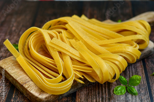 Raw fresh uncooked tagliatelle egg pasta . Ready for cooking. Italian food concept. Kitchen poster
