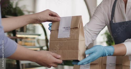 Asia people woman hand glove or face mask happy enjoy buy fast food carry send paper box pick up take home to-go lunch meal. Small cafe coffee shop work with wrap care new normal for SME omni channel.