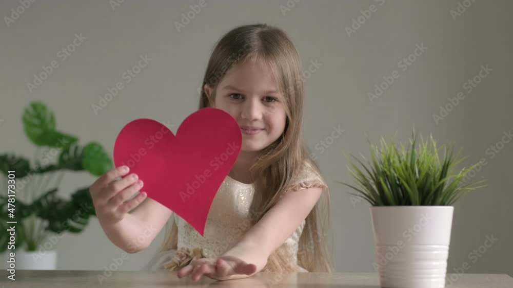 Little cute girl holding big red paper heart and sending air kiss. Valentines Day, love, mothers or fathers Day, romantic concept. Adorable kid smiling and looking at camera. Little cute girl holding big red paper heart and sending air kiss. Valentines Day, love, mothers or fathers Day, romantic concept. Adorable kid smiling and looking at camera.