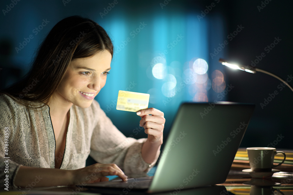 Happy woman holding credit card buying on line at home Happy woman holding credit card buying on line at home