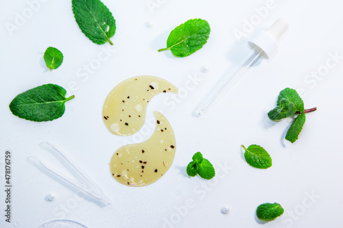 Hydrogel cosmetic moisturizing and refreshing collagen eye patches on white background with peppermint leaves and water drops