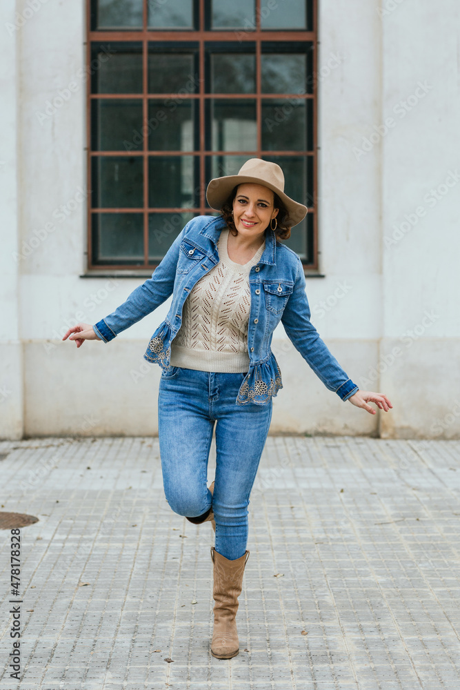Woman smiling and looking at the camera while posing outdoors on the street. Woman smiling and looking at the camera while posing outdoors on the street.