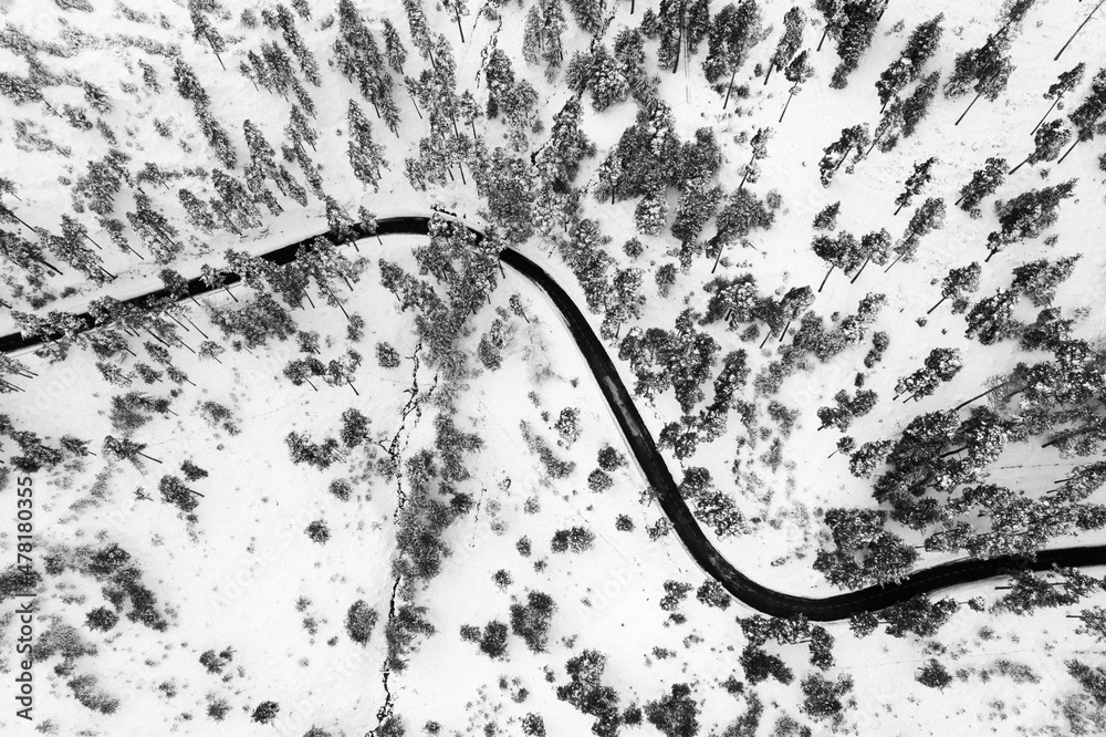 Aerial shot of a curvy road on a winter landscape