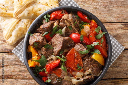 Buglama Traditional hot ragout with meat and vegetables closeup in the Bowl on the wooden table. Horizontal top view from above photo