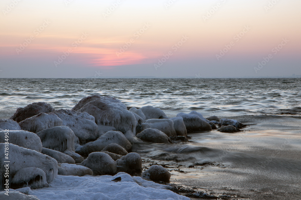 Obraz premium ice covered stones by the sea in winter.