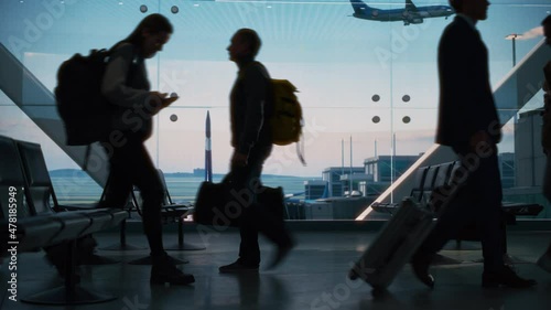 Busy Airport Terminal: Diverse Multi-Ethnic Crowd of People Walking, Hurry or Wait for their Flights. People Sitting in a Boarding Lounge of Big Airline Hub with Airplanes Departing and Arriving