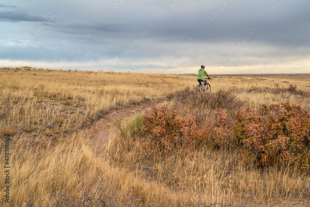 senior cyclist is riding a mountain bike on a single track trail in Colorado prairie - Soapstone Prairie Natural Area with last fall colors in late October
