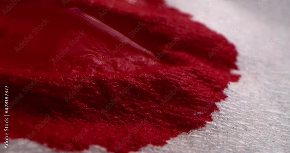 Drops of blood drip onto a paper napkin, blood spreads over the napkin. Red blood drops onto a white cloth, blood is absorbed into a white paper napkin, macro shot.