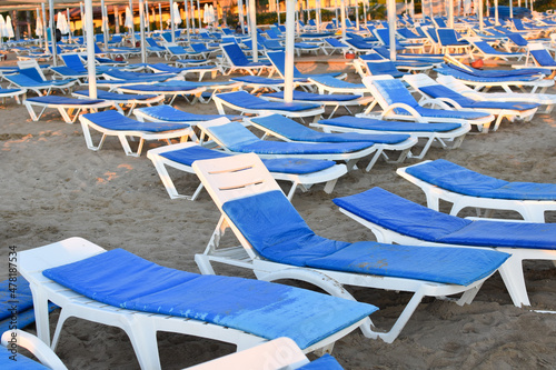 sun loungers for sunbathing on sea beach. sun loungers by blue sea in summer without people