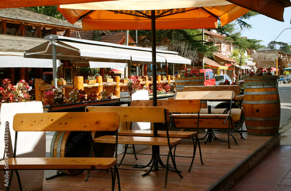 Bar, restaurant. City of Villa General Belgrano, Córdoba, Argentina. Tourist city in the mountains of Cordoba. Oktoberfest venue. National beer festival. 
Tables and chairs of a European German style. - obrazy, fototapety, plakaty 