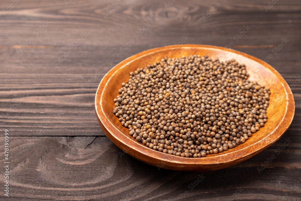 coriander seeds in a wooden bowl coriander seeds in a wooden bowl