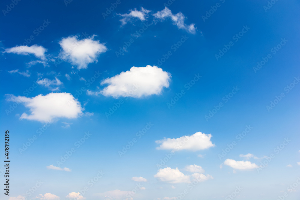 sky with fluffy clouds. white cumulus sparse cloudscape on a deep blue gradient of atmosphere. sunny summer weather. beautiful nature background. meteorology backdrop. fresh air. freedom concept