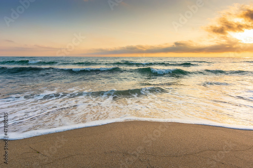 golden sand on the beach in summer. beautiful glowing clouds above the horizon. panoramic seascape at sunrise. relaxing summer mood in morning light. vacation concept background