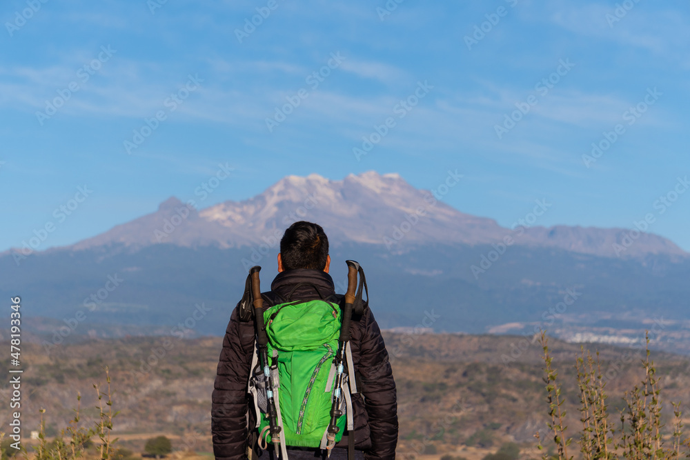Anonymous man with only her back visible overlooking volcano iztaccihuatl.