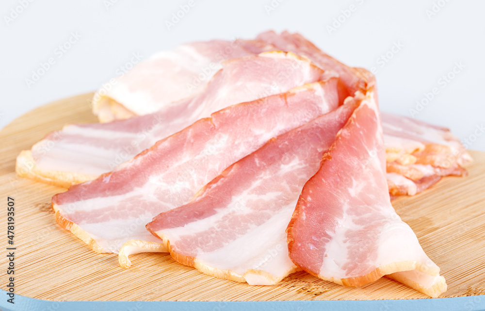 Bacon slices on a wooden cutting board Bacon slices on a wooden cutting board